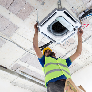 Technician working on a ceiling cassette air conditioner