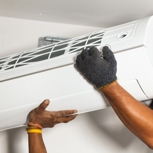 Technician installing a wall mounted air conditioner